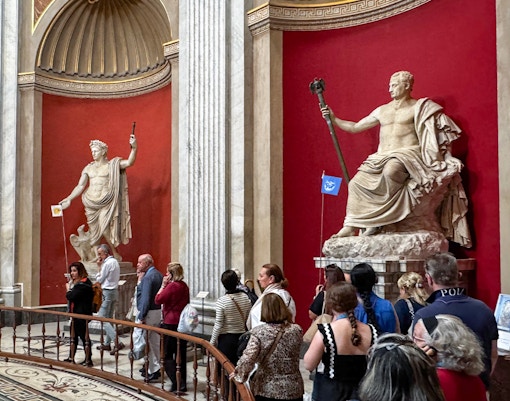 Visitors viewing classical statues in the Round Hall, Vatican Museums, Rome, Italy.