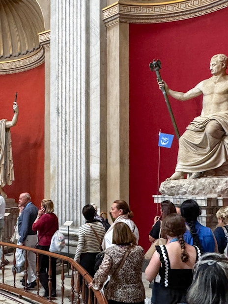Visitors viewing classical statues in the Round Hall, Vatican Museums, Rome, Italy.