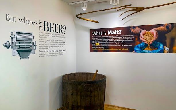 Prague Beer Museum exhibit on beer production with malt and brewing tools.
