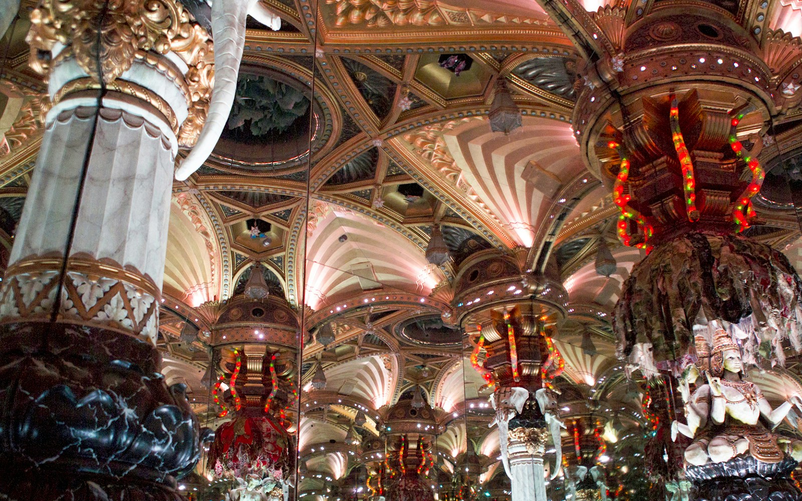 Hall of Mirrors at Grévin Museum Paris with ornate columns and mirrored reflections.