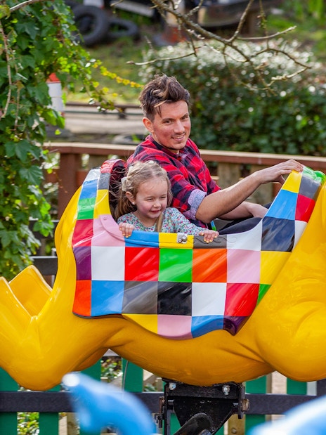 Family enjoying a colorful elephant ride at a theme park.