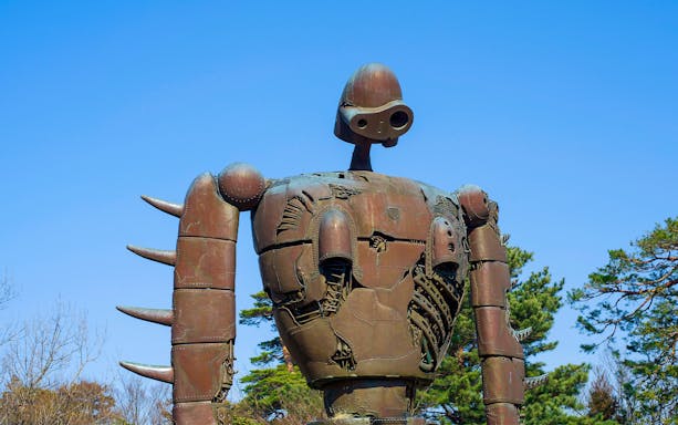Robot statue at Studio Ghibli Museum in Japan under clear blue sky.