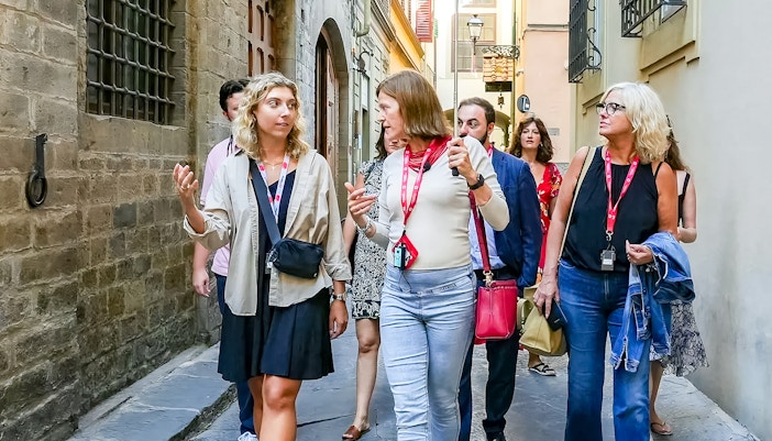 Heart of Florence Walking Tour group exploring the historic city center with a guide, featuring a view of the iconic Duomo cathedral
