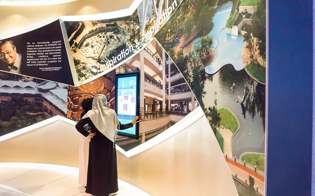 Visitors exploring Petronas Twin Towers exhibit in Kuala Lumpur.
