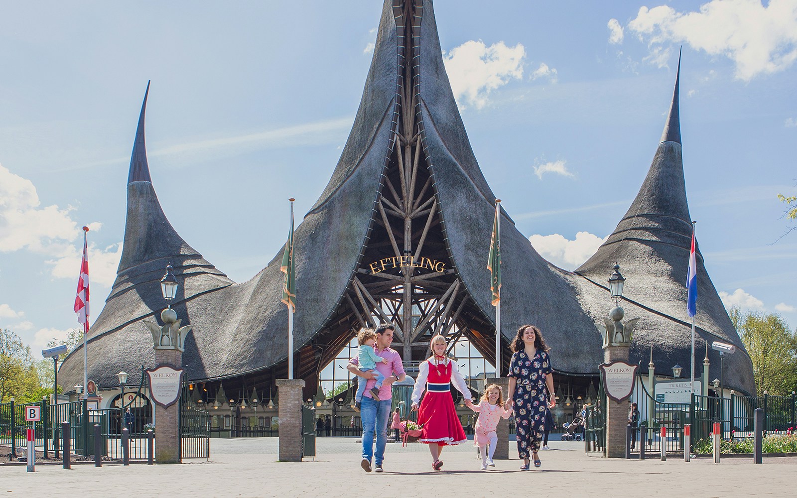 Family walking in front of Efteling Theme Park entrance with iconic spire architecture.