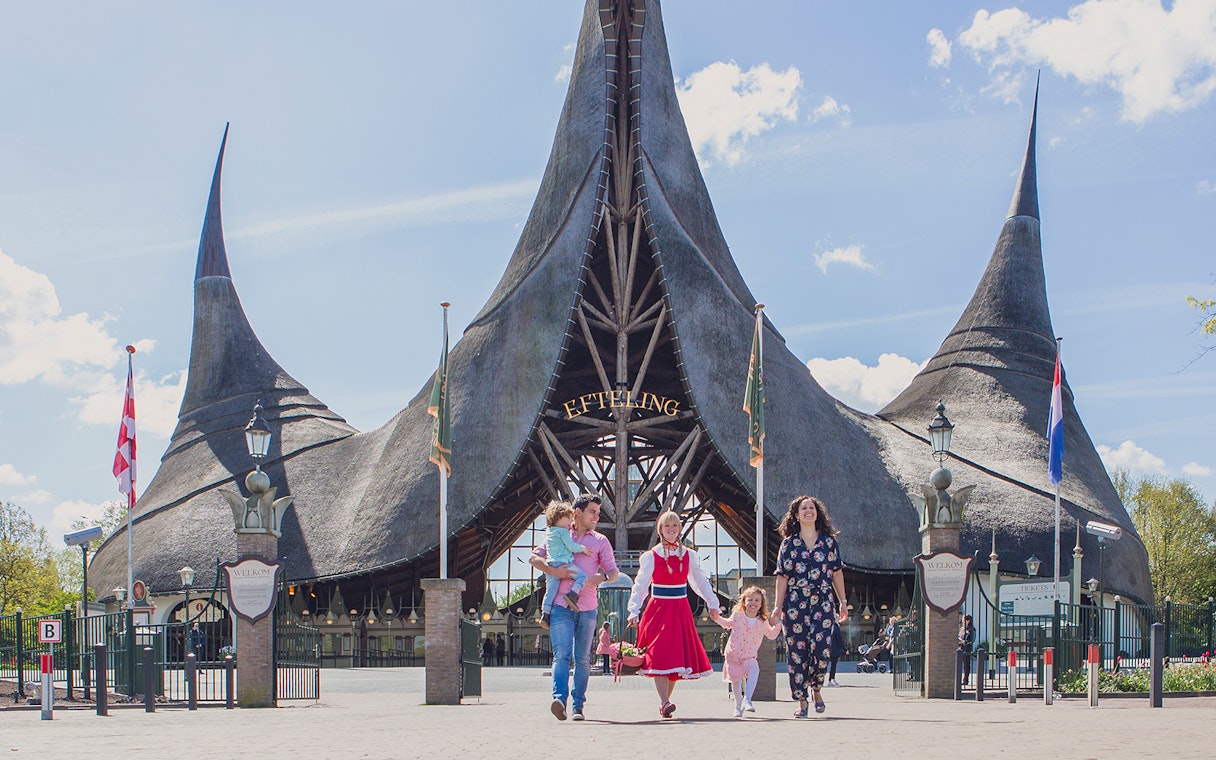 Family walking in front of Efteling Theme Park entrance with iconic spire architecture.