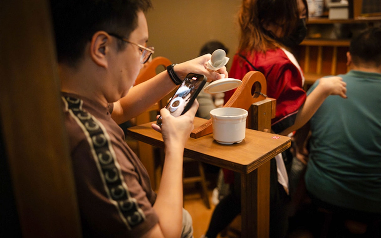 Guest captures coffee preparation at Wonderland Upside Down experience.