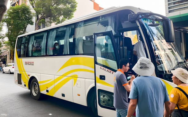 Tourists boarding a bus for the Mekong Delta day tour from Ho Chi Minh City.