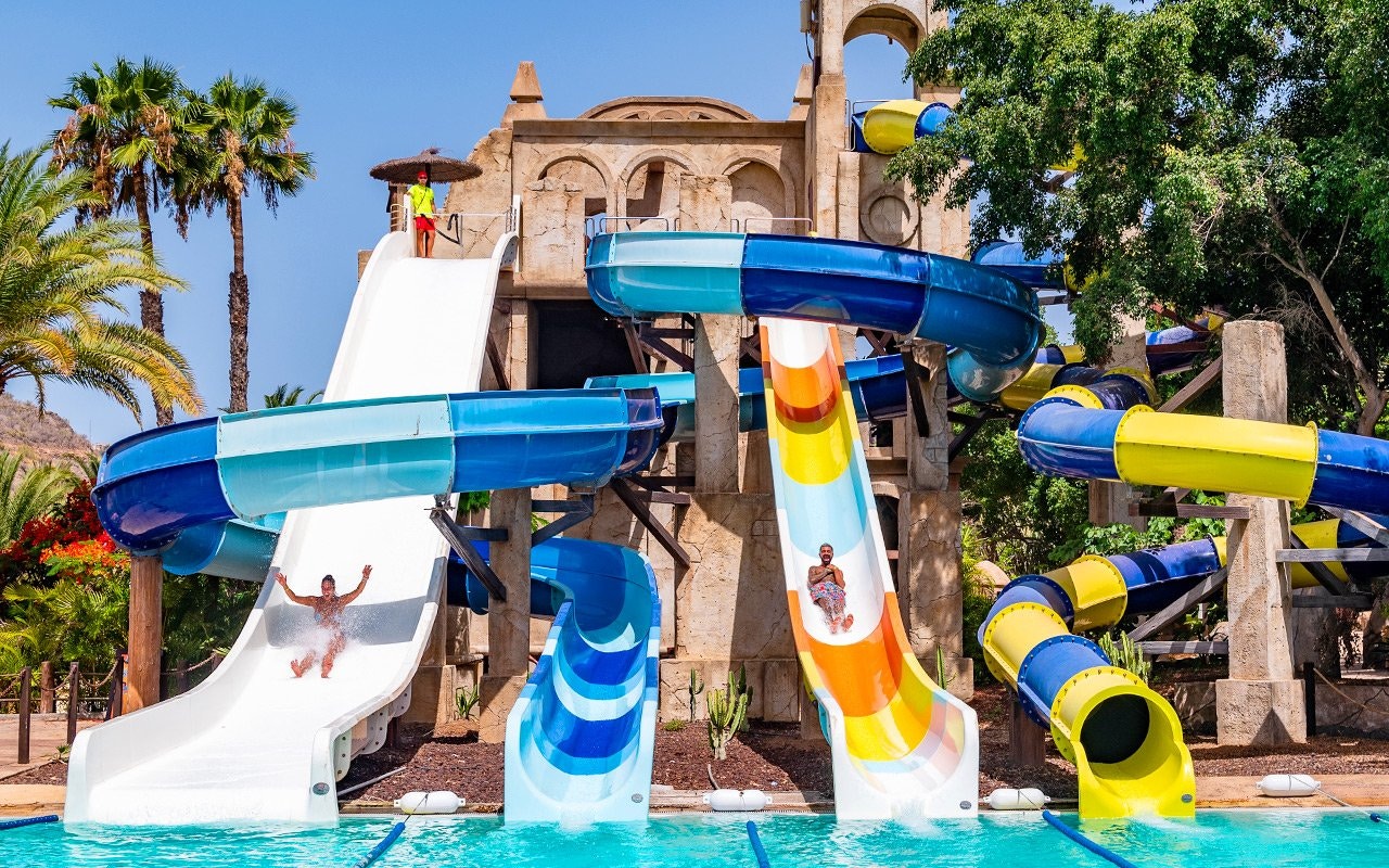Visitors enjoying water slides at Aqualand Maspalomas, featuring Snake Falls.