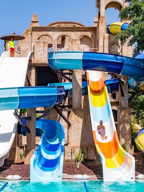 Visitors enjoying water slides at Aqualand Maspalomas, featuring Snake Falls.