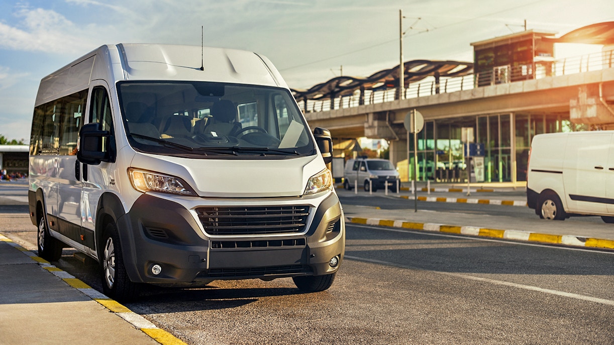 Shuttle bus parked near a station in Dubai, serving Atlantis, IMG, Dubai Parks, and Yas Island.