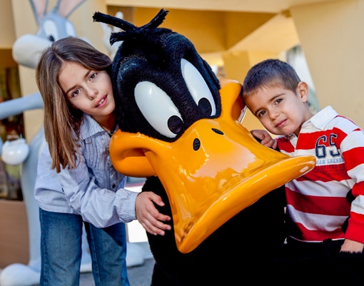 children posing with daffy duck at parque warner madrid