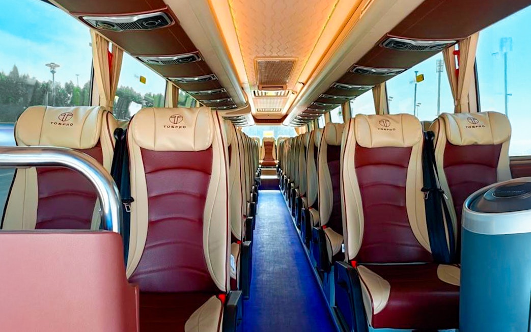 Interior of a tour bus with comfortable seating for Aquaventure Waterpark visitors.