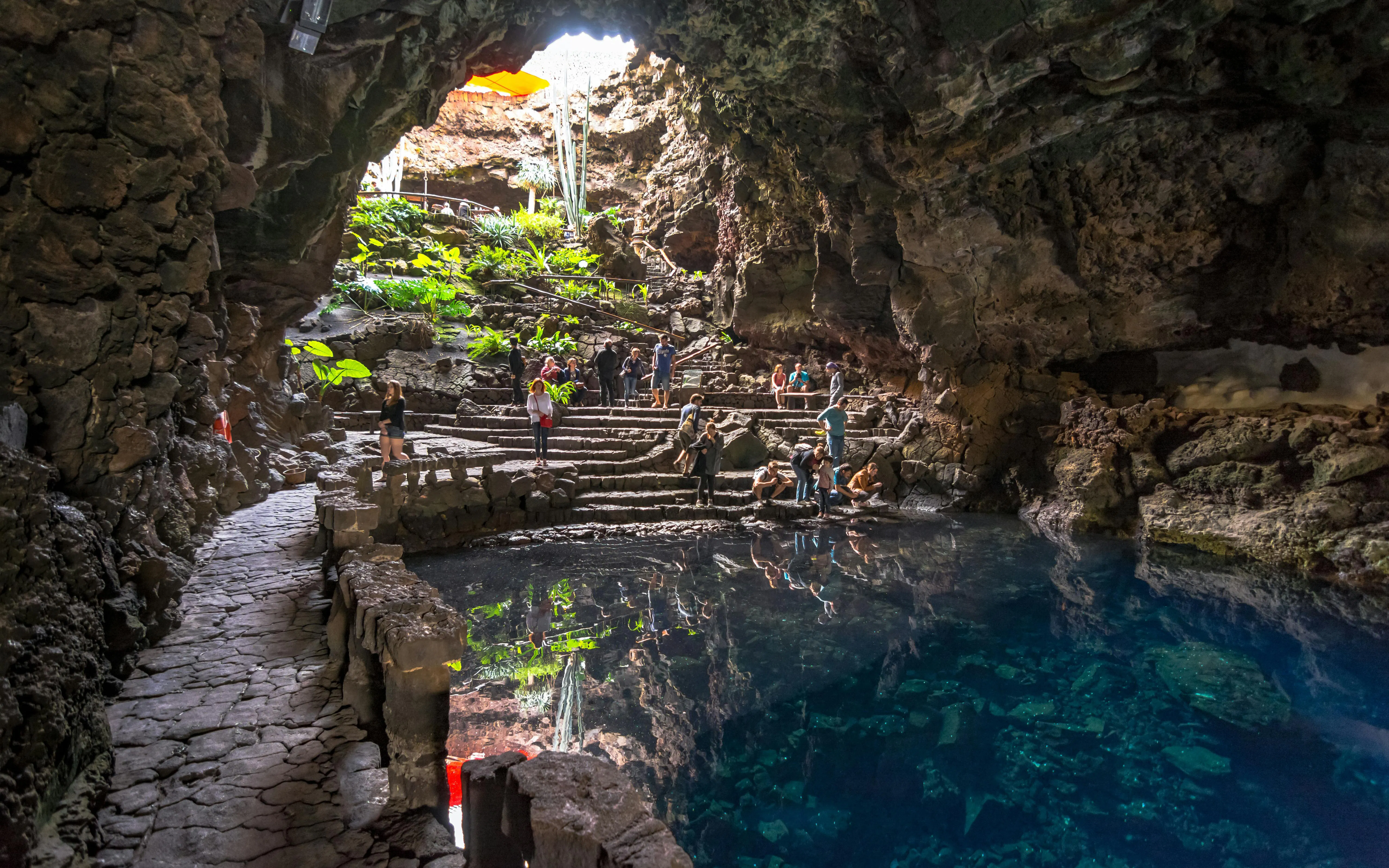 Visitors exploring Jameos del Agua cave and lake in Lanzarote, Canary Islands.