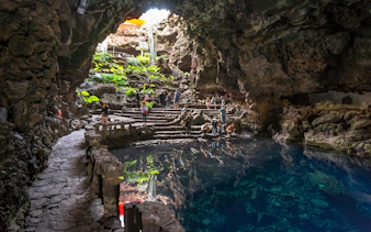 Visitors exploring Jameos del Agua cave and lake in Lanzarote, Canary Islands.