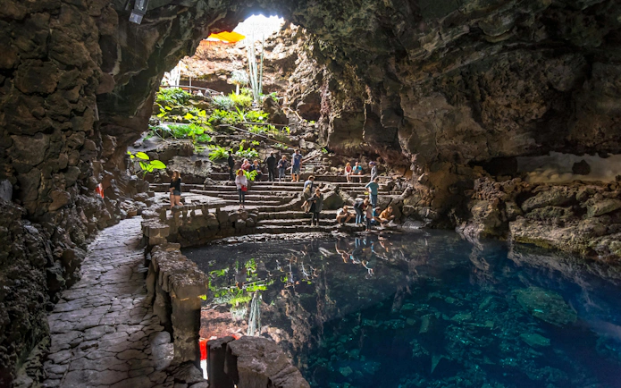 Visitors exploring Jameos del Agua cave and lake in Lanzarote, Canary Islands.
