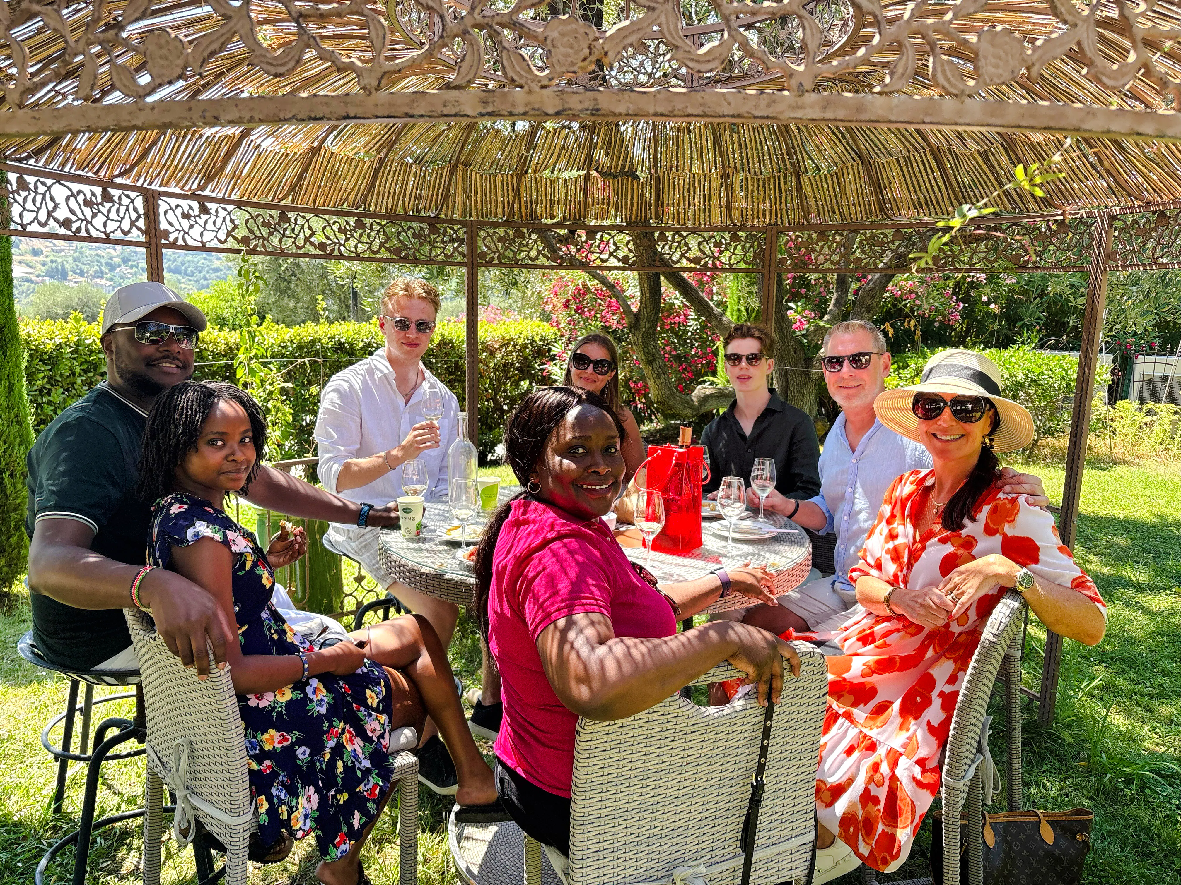 Group enjoying wine tasting at a historic château in Nice garden setting.