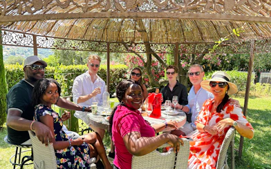 Group enjoying wine tasting at a historic château in Nice garden setting.