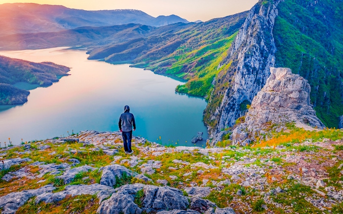 Hiker overlooking Bovilla Lake from Gamti Mountain during private tour.