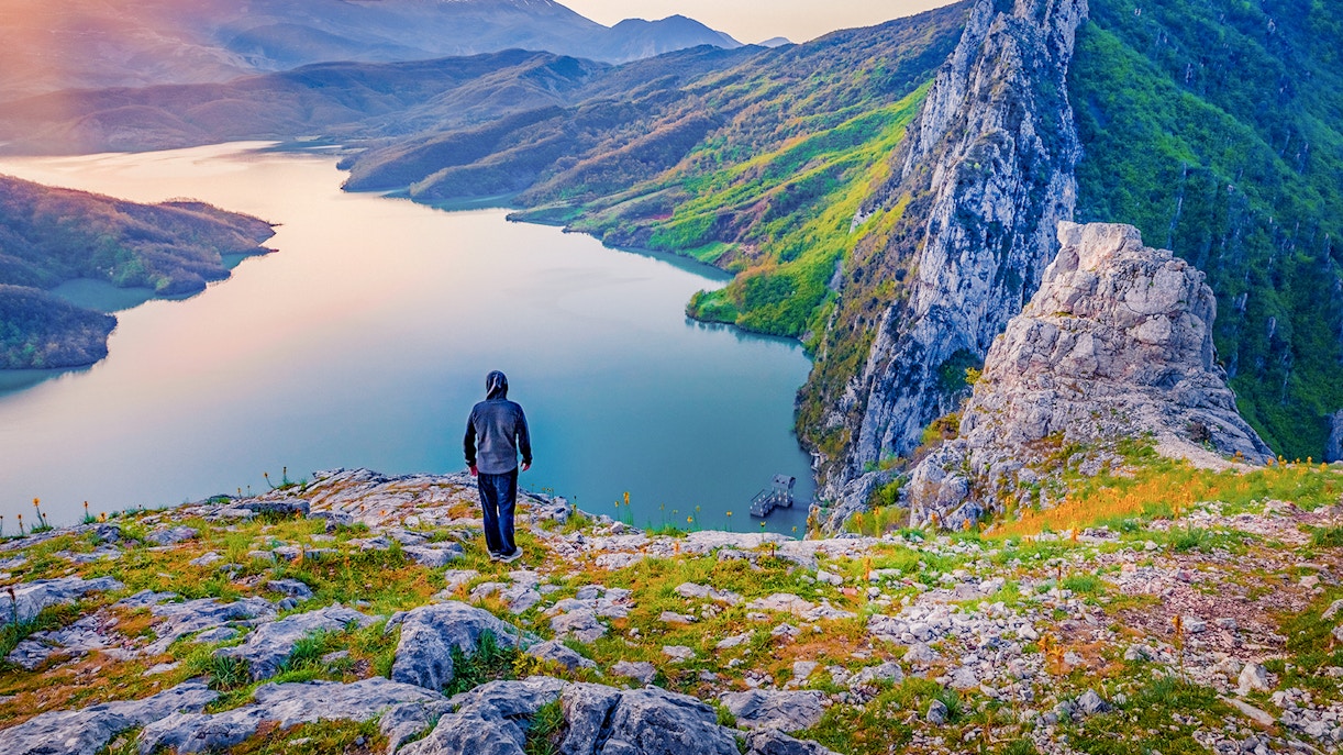 Hiker overlooking Bovilla Lake from Gamti Mountain during private tour.