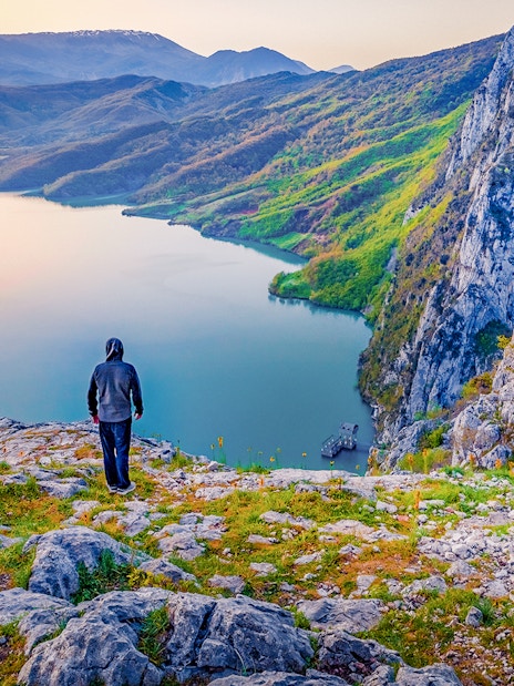 Hiker overlooking Bovilla Lake from Gamti Mountain during private tour.