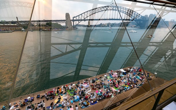 Sydney Opera House view with people gathered for NYE Opera Gala, overlooking Sydney Harbour Bridge.
