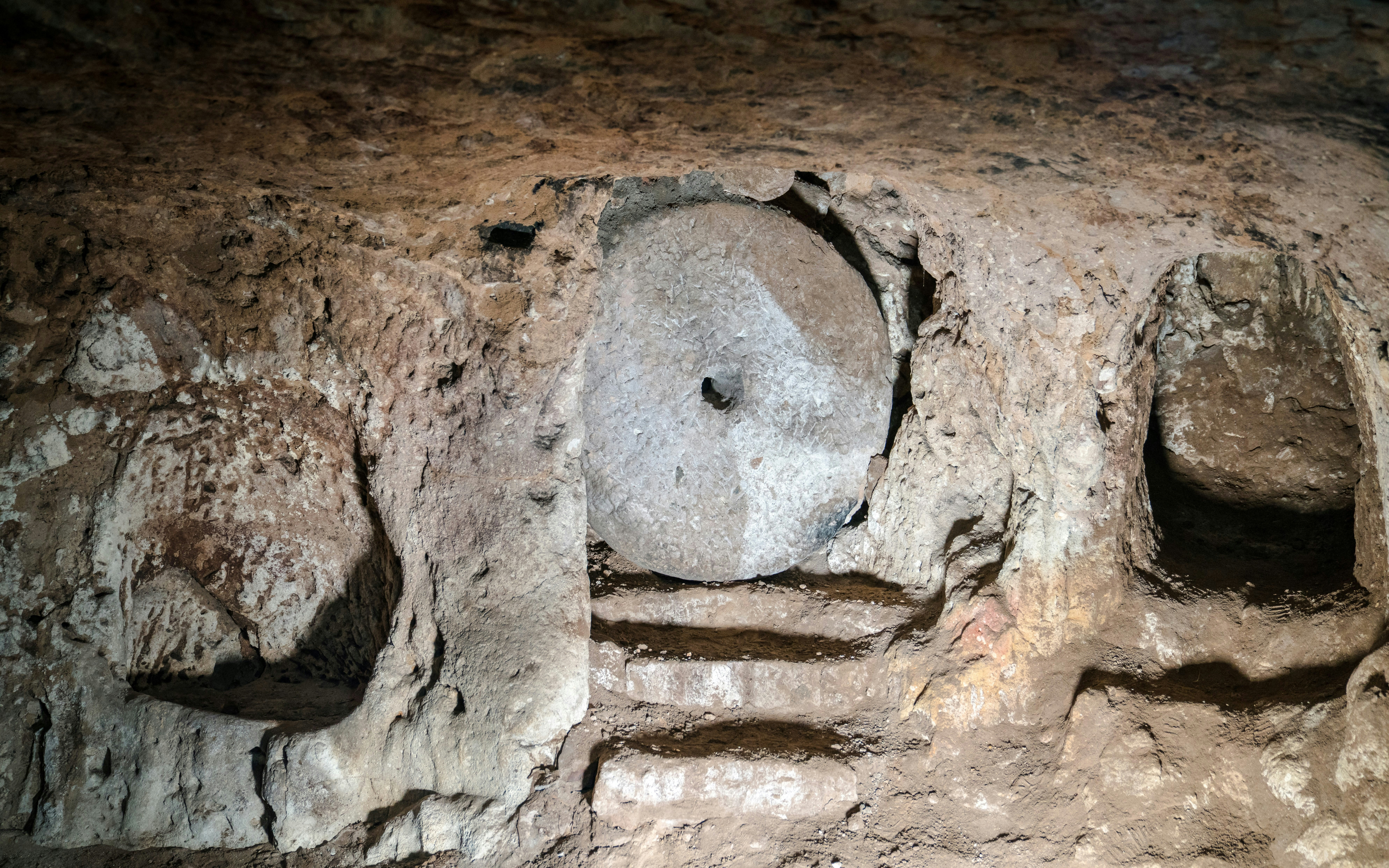 Stone wheel door in Ozkonak underground city, Cappadocia, Turkey.