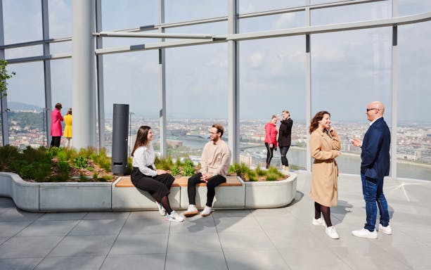 People enjoying the view from SkyDeck at MOL Campus, Budapest, overlooking the city and river.