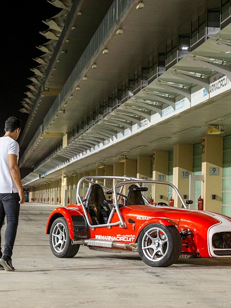 Caterham Seven 360 parked at Yas Marina Circuit with a person holding a helmet nearby.
