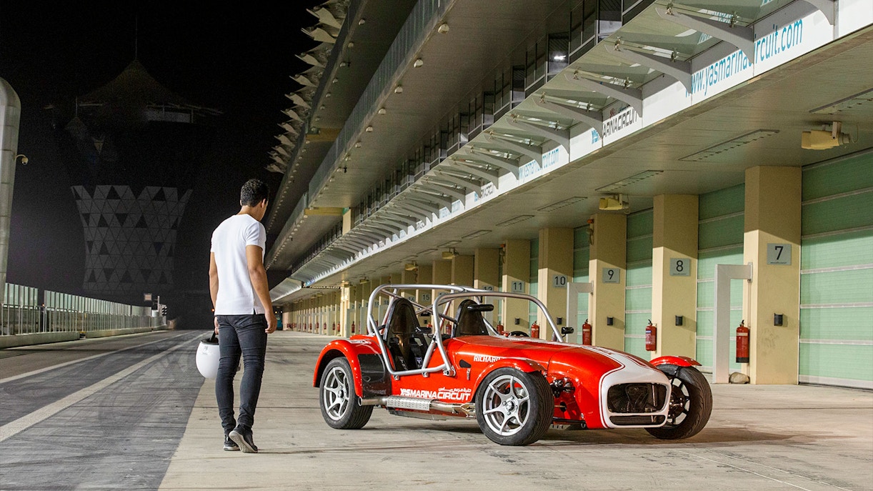 Caterham Seven 360 parked at Yas Marina Circuit with a person holding a helmet nearby.