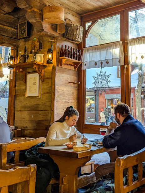 Couple dining at a rustic cafe in Zakopane, Poland.