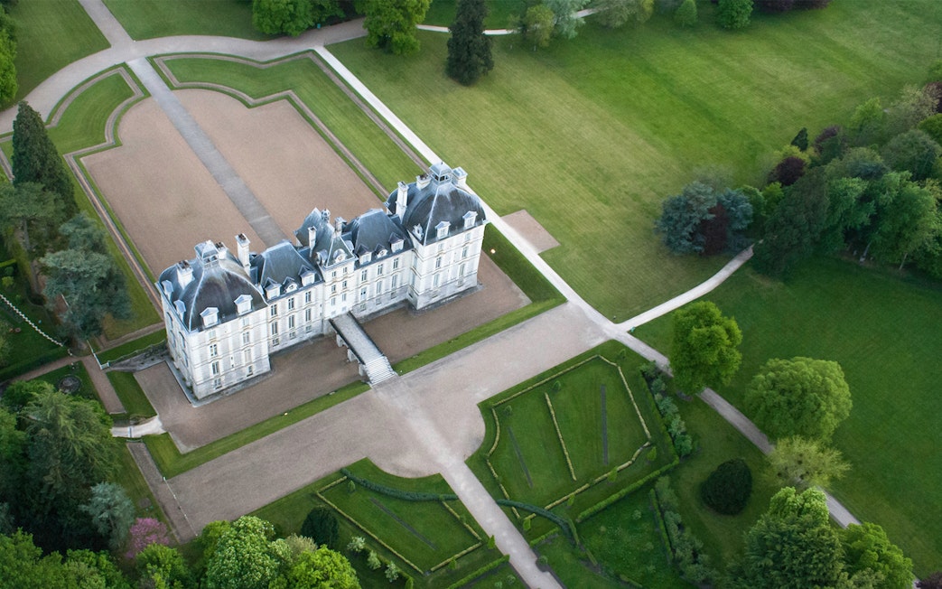 Aerial view of a château in the Loire Valley surrounded by gardens and greenery.