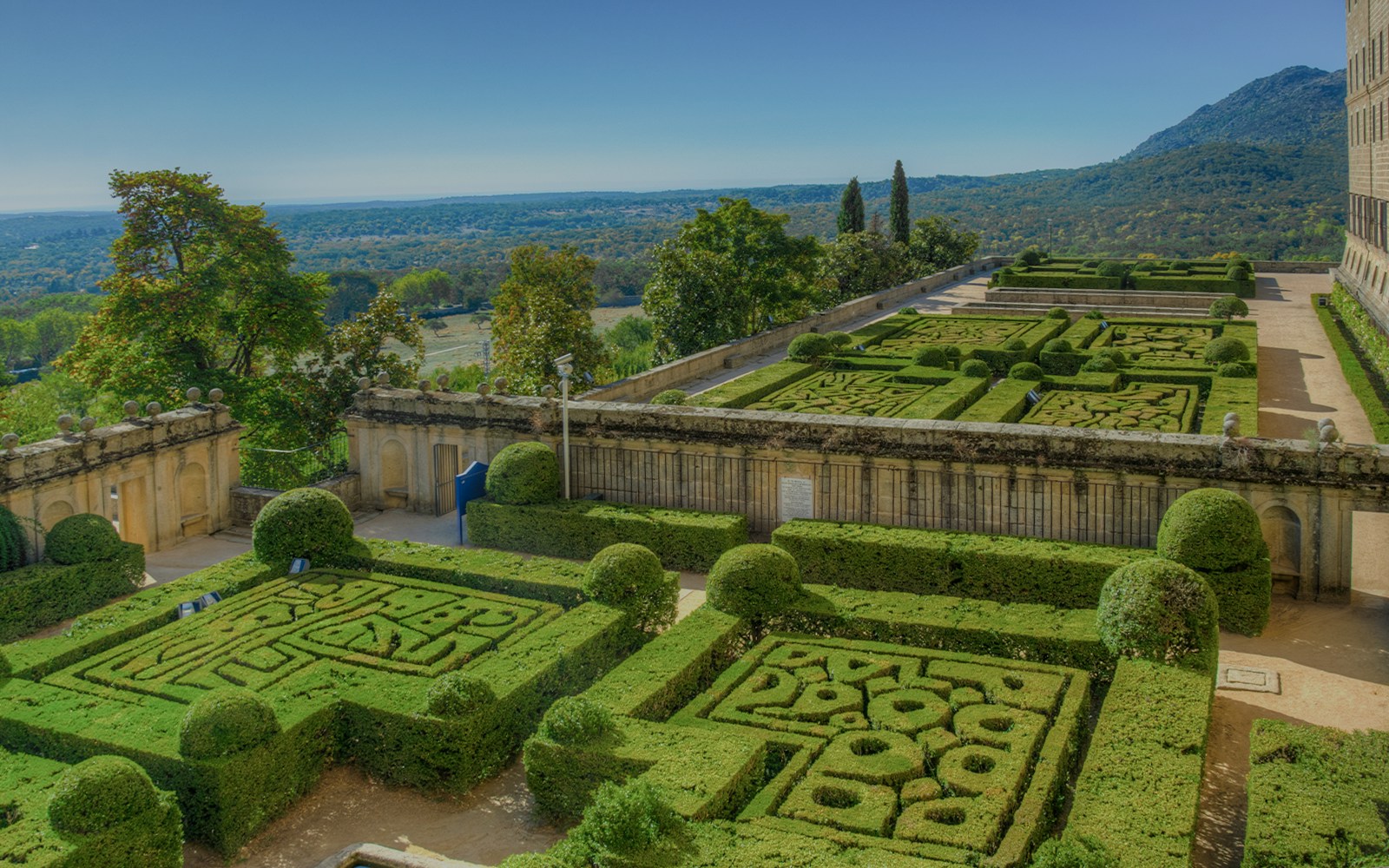 Gardens of the Royal Seat of San Lorenzo de El Escorial with manicured hedges near Madrid, Spain.