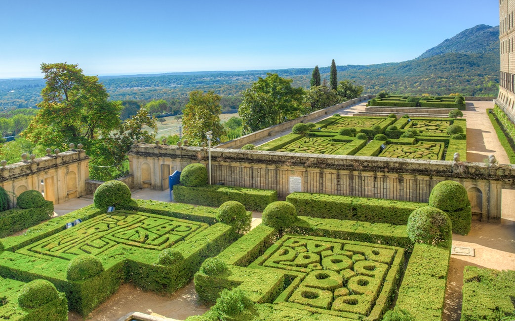 Gardens of the Royal Seat of San Lorenzo de El Escorial with manicured hedges near Madrid, Spain.