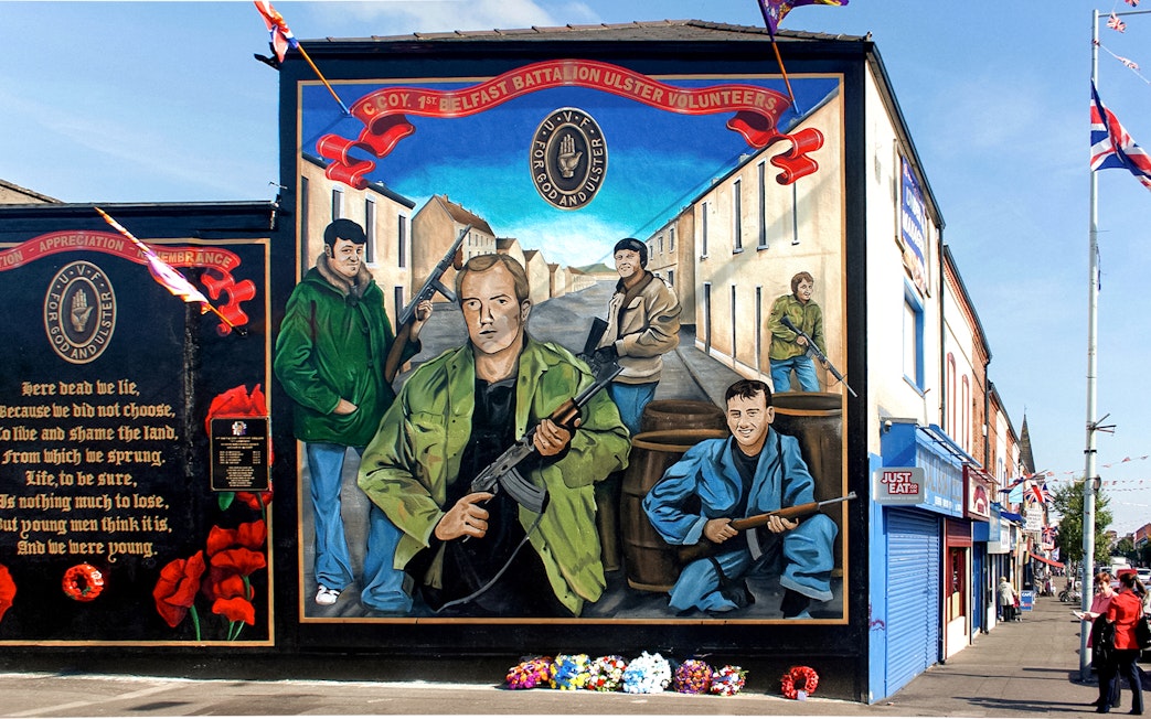 Belfast mural depicting Ulster Volunteer Force members on a street, part of a political taxi tour.