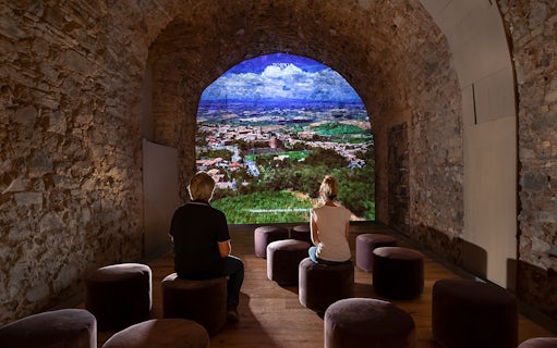 Visitors viewing a projection of Montalcino landscape at Museum of Brunello di Montalcino.