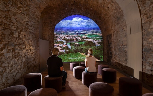 Visitors viewing a projection of Montalcino landscape at Museum of Brunello di Montalcino.