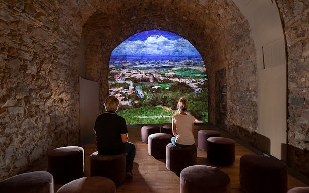 Visitors viewing a projection of Montalcino landscape at Museum of Brunello di Montalcino.