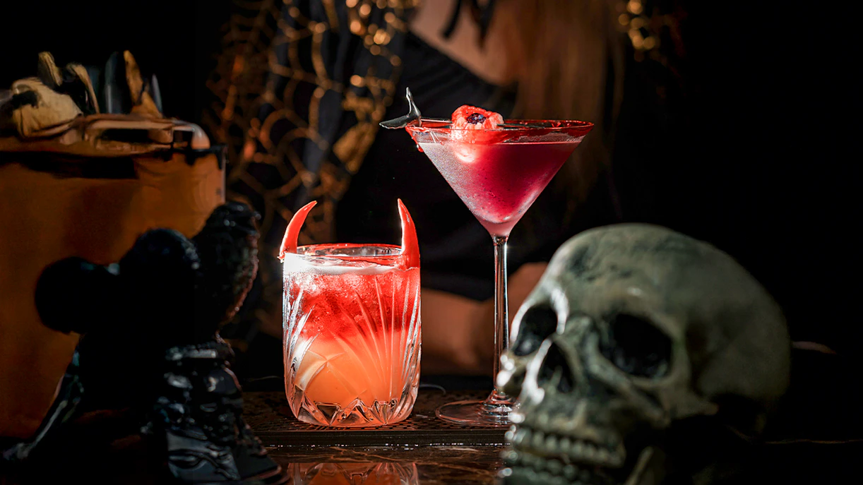 Halloween-themed cocktails with devil horns and skull decoration.