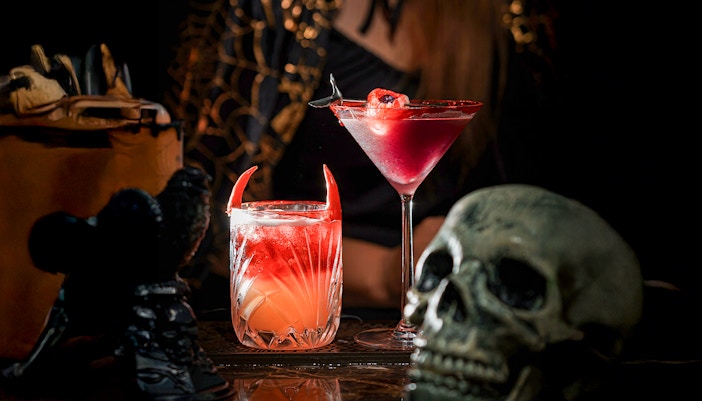 Halloween-themed cocktails with devil horns and skull decoration.