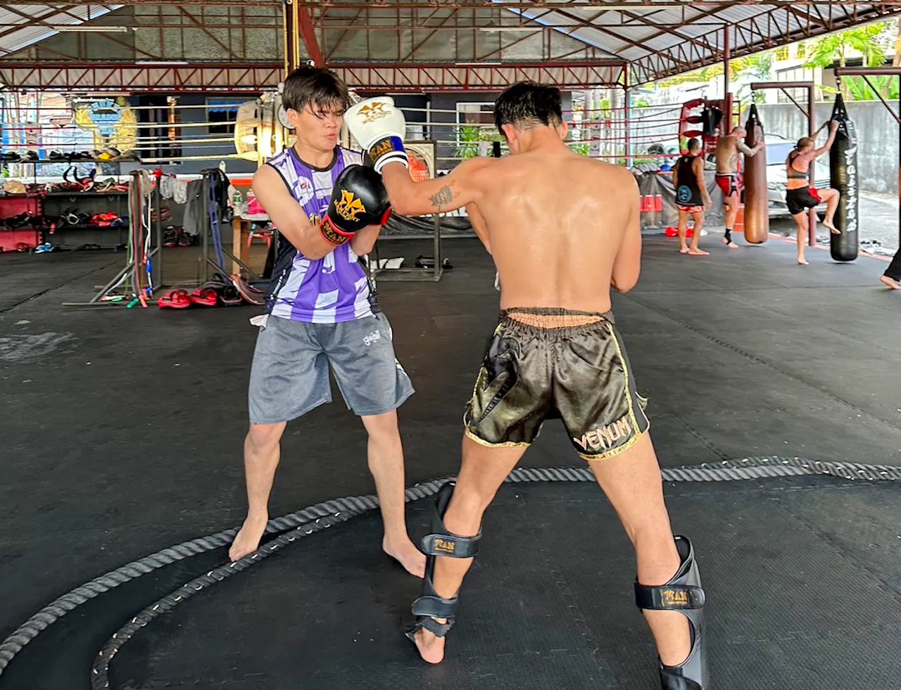 Muay Thai beginners practicing boxing techniques in a Phuket training gym.