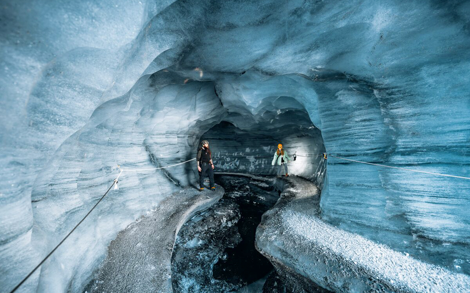 Guests exploring the icy interior of Katla Ice Cave in Iceland.