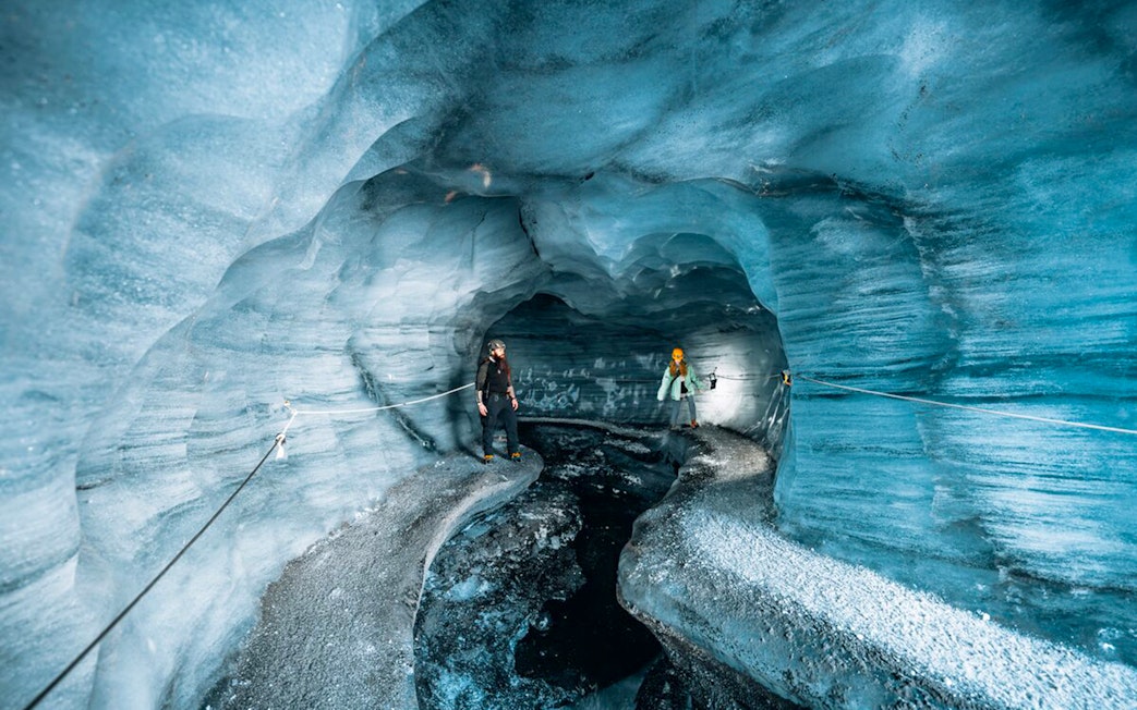 Guests exploring the icy interior of Katla Ice Cave in Iceland.