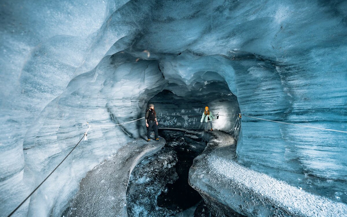 Guests exploring the icy interior of Katla Ice Cave in Iceland.
