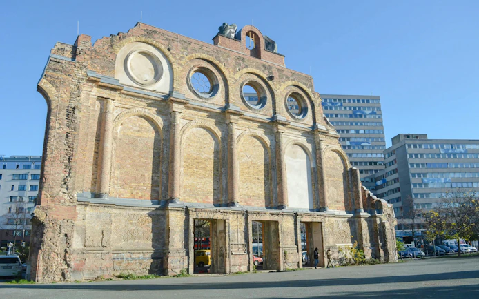 Ruins of Anhalter Bahnhof facade in Berlin with modern buildings in the background.