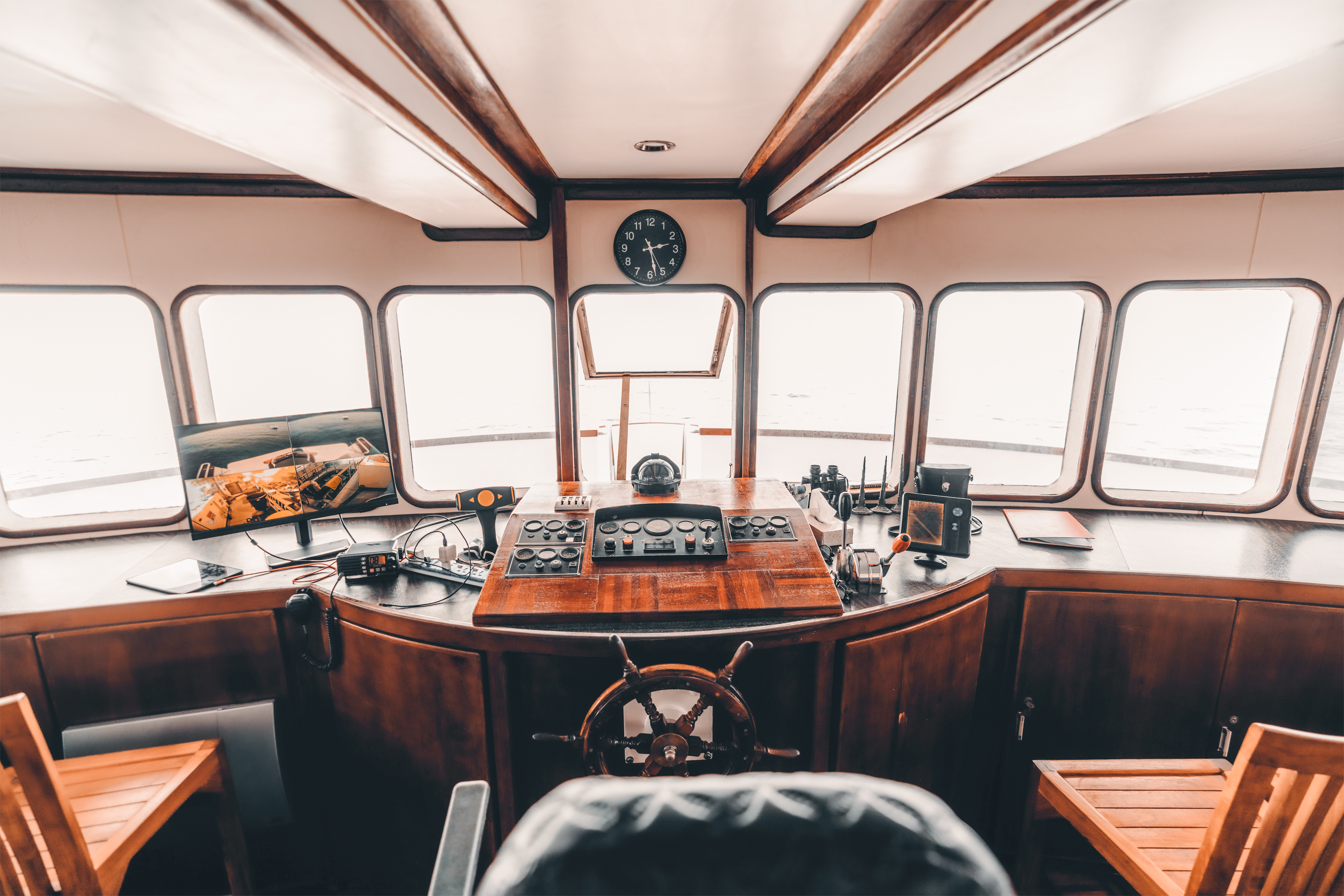 Captain's cabin with navigation equipment and steering wheel on a ship.