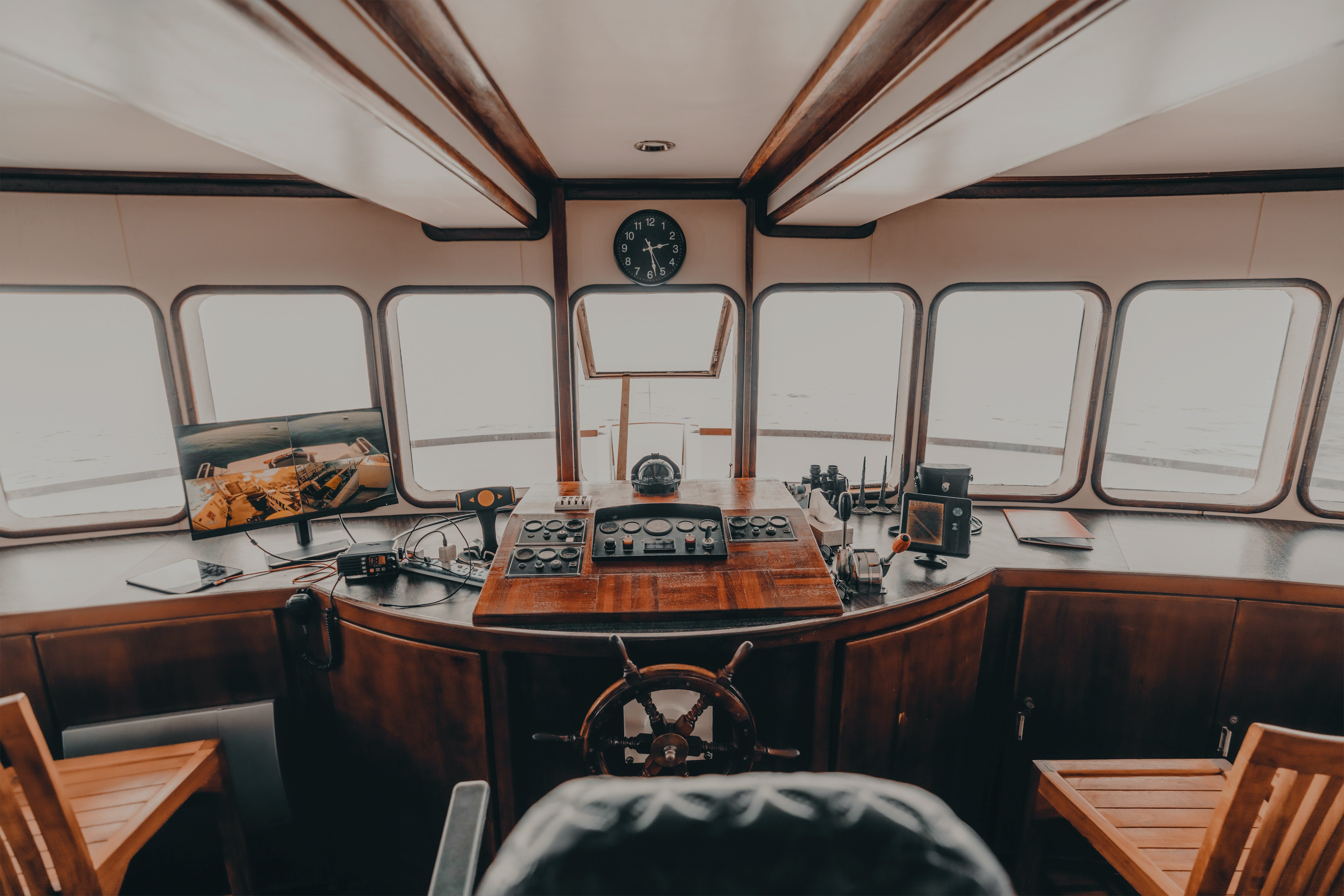 Captain's cabin with navigation equipment and steering wheel on a ship.
