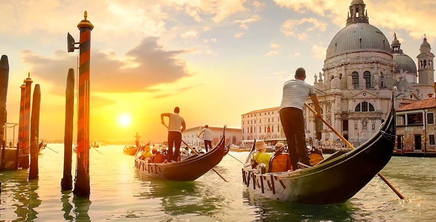Gondolas on Venice canal at sunset near Santa Maria della Salute.