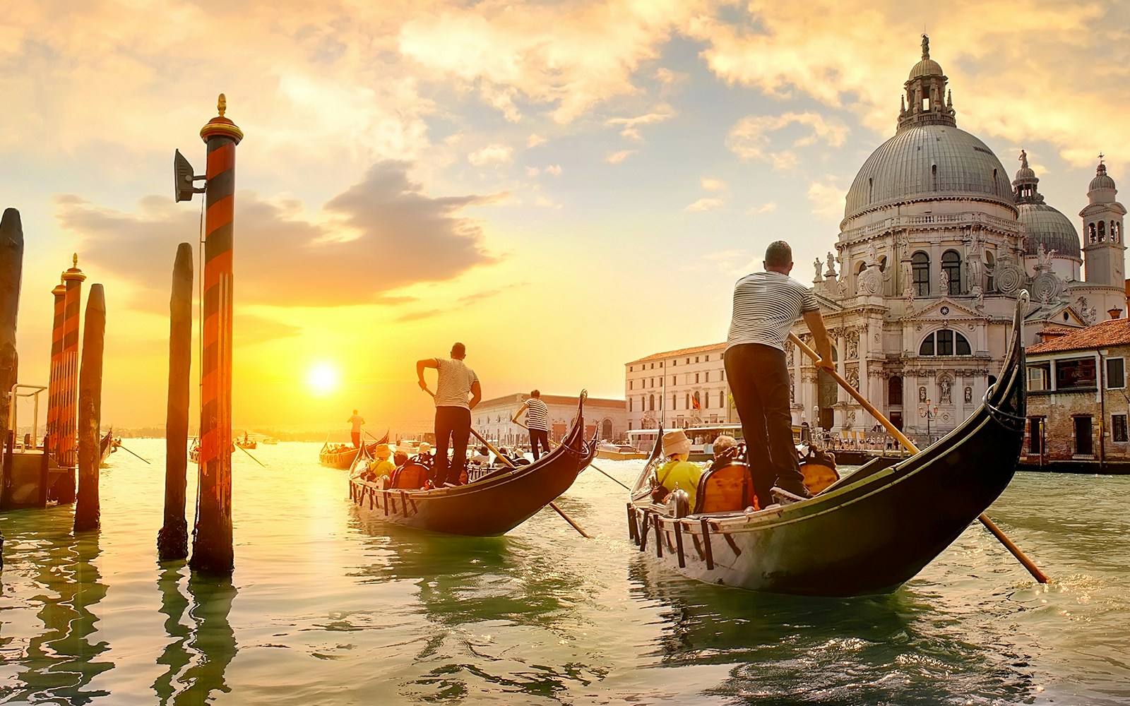 Gondolas on Venice canal at sunset near Santa Maria della Salute.