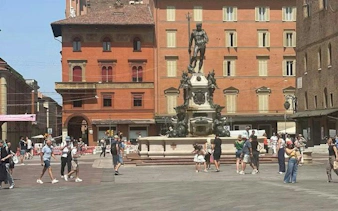 Neptune Fountain in Piazza del Nettuno, Bologna, with tourists exploring the square.